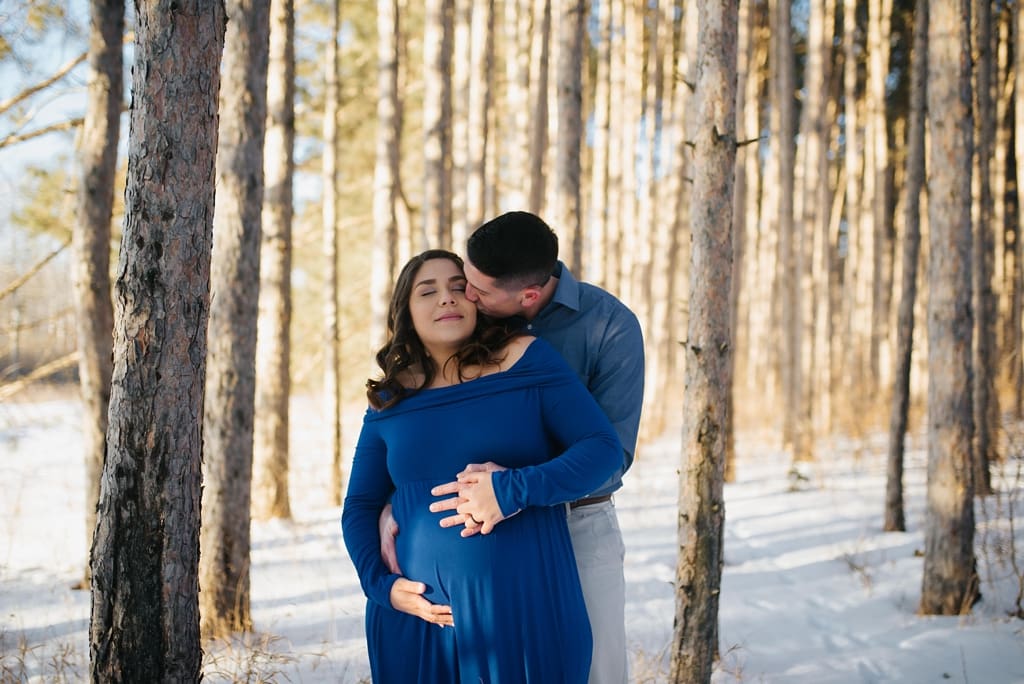 couple kisses in minnesota woods