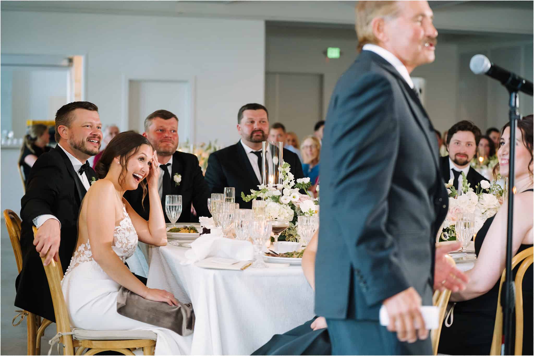 couple laughing during speeches during nisswa wedding reception in minnesota